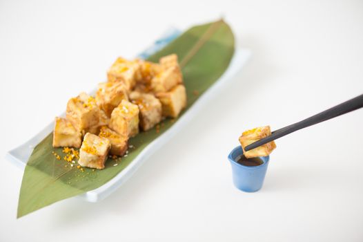Fake fried tofu (using eggplant replace to tofu) on Japanese bamboo leaf with small cup of plum sauce