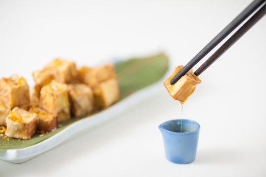 Fake fried tofu (using eggplant replace to tofu) on Japanese bamboo leaf with small cup of plum sauce