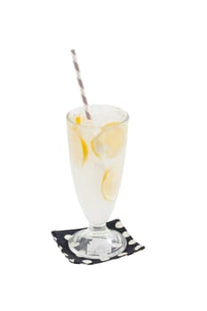 Iced lemonade in glass with striped straw garnished with lemon isolated on white background with clipping path
