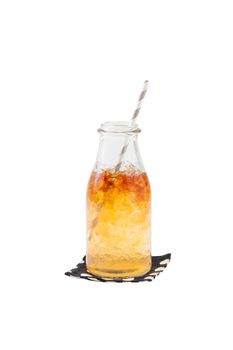 Iced carramel tea in glass bottle with striped straw isolated on white background with clipping path