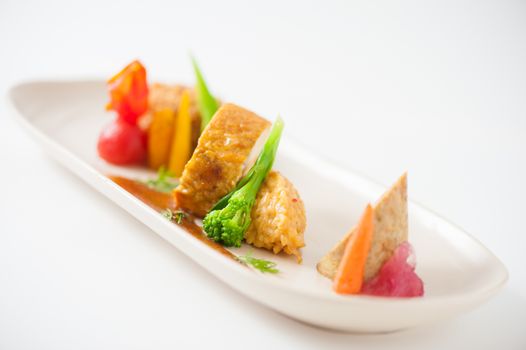 3 modern cuisine Prosciutto Wrapped Chicken with resotto and tamarind sauce, Fried mussaman curry, and Thai chicken spicy sausage on ceramic dish garnished with vegetables