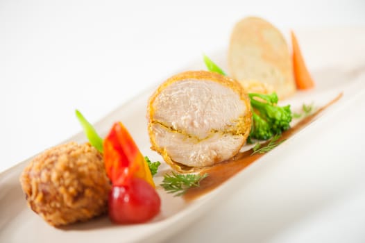 3 modern cuisine Prosciutto Wrapped Chicken with resotto and tamarind sauce, Fried mussaman curry, and Thai chicken spicy sausage on ceramic dish garnished with vegetables
