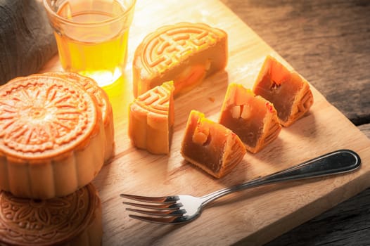 Moon cake, Chinese mid autumn festival dessert on wood board with dramatic morning scene