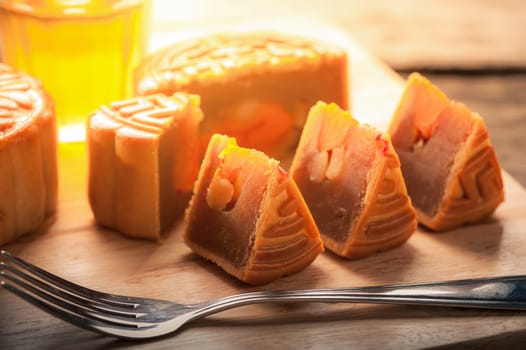 Moon cake, Chinese mid autumn festival dessert on wood board with dramatic morning scene