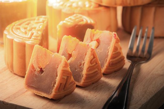 Moon cake, Chinese mid autumn festival dessert on wood board with dramatic morning scene