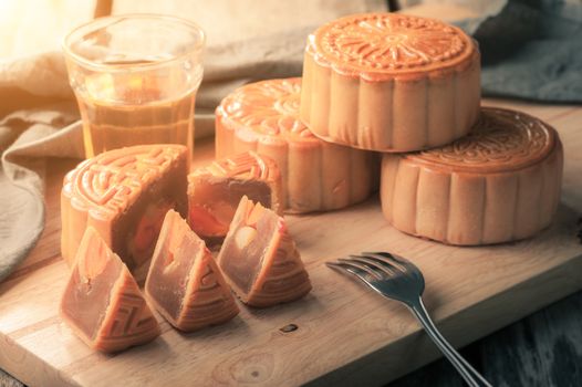 Moon cake,Chinese mid autumn festival dessert on wood board with dramatic morning scene