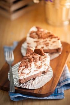 Chocolate cookie cheese cake on wood table with vintage scene in morning