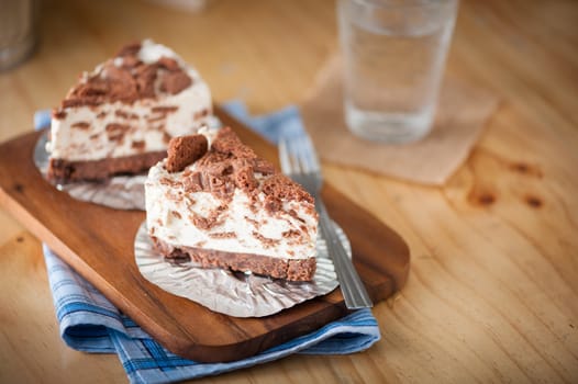 Chocolate cookie cheese cake on wood table with vintage scene in morning