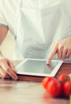 cooking, technology and home concept - closeup of man pointing finger to tablet pc computer