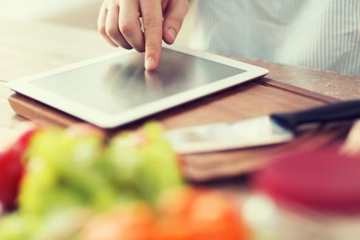 cooking, technology and home concept - closeup of man pointing finger to tablet pc computer