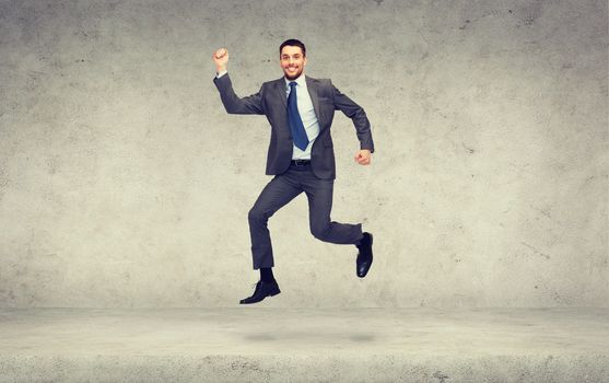 business and education concept - smiling businessman jumping