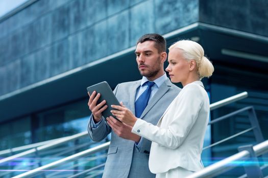 business, partnership, technology and people concept - businessman and businesswoman working with tablet pc computer on city street