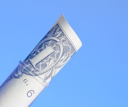 one dollar in test tube, cost of medical health care on light blue background