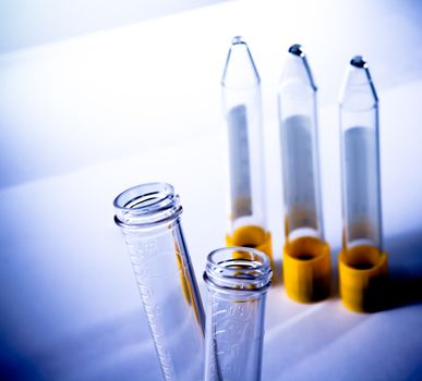 detail of the test tubes in laboratory on table and blue light tint background