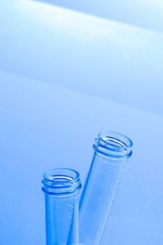 empty test tubes in laboratory on table and blue light tint background