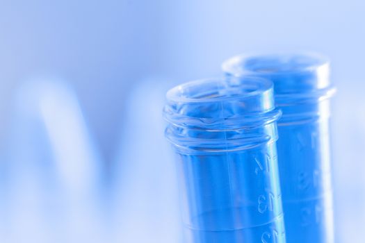 test tubes in laboratory on blue light tint background with space for text