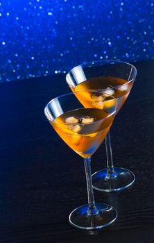 glasses of fresh cocktail with ice on blue tint light background on bar table with space for text