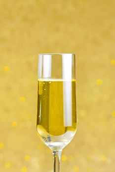 one flute of champagne on golden bokeh background