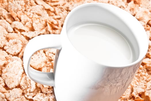 cup of milk on corn flakes background, nutrition concept