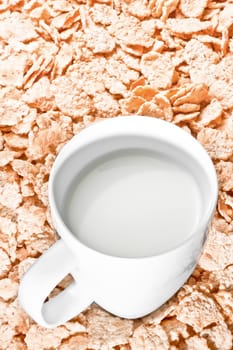 top of view of cup of milk on corn flakes background, breakfast concept