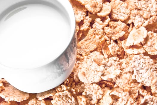top of view of cup of milk on corn flakes background