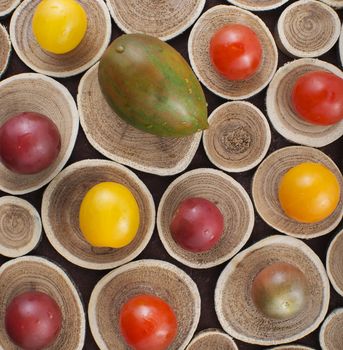 Different colorful whole cherry tomatoes on wood background