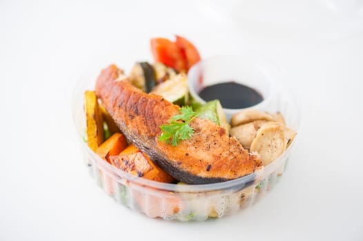 Salmon steak and grilled vegetables cooked by clean food concept with Japanese sesame soy sauce in lunch box