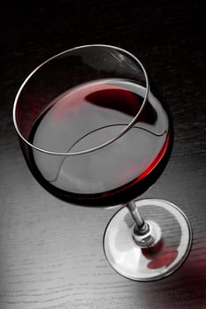top of view of red wine glass on black wood table
