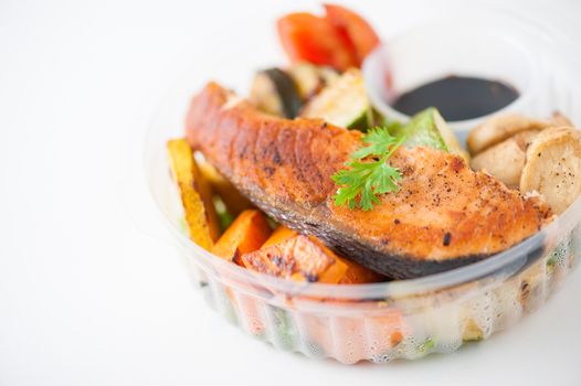 Salmon steak and grilled vegetables cooked by clean food concept with Japanese sesame soy sauce in lunch box