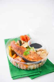 Salmon steak and grilled vegetables cooked by clean food concept with Japanese sesame soy sauce in lunch box