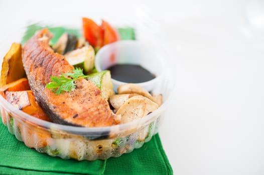 Salmon steak and grilled vegetables cooked by clean food concept with Japanese sesame soy sauce in lunch box