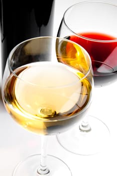 top of view of red and white wine glasses with black bottle on white background