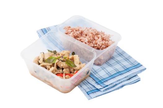 Stir freid basil with chicken breast and Termitomyces cooked by clean food concept with brown rice in lunch box isolated on white background with clipping path
