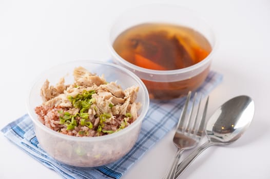 Brown rice gruel with chicken breast with vegetables soup cooked by clean food concept in separate lunch box on white table