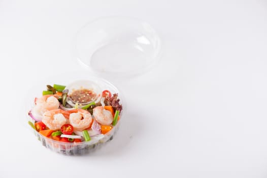 Thai spicy salad with shrimps cooked by clean food concept in lunch box on white table