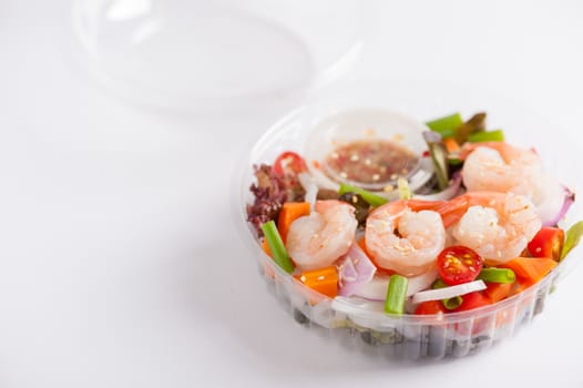 Thai spicy salad with shrimps cooked by clean food concept in lunch box on white table