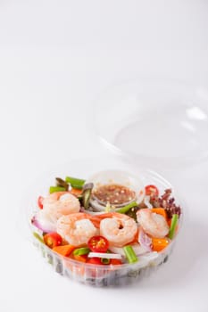Thai spicy salad with shrimps cooked by clean food concept in lunch box on white table