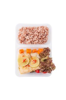 Thai style steamed fish in spicy lemon sauce cooked by clean food concept with vegetables and brown rice in lunch box isolated on white background