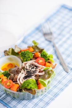 Chicken breast salad with honey thyme sauce cooked by clean food concept in lunch box on white table