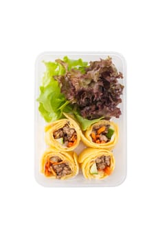 Thai spicy egg rolls (Fresh spring rolls, Kuay Teaw Lui Suan but use egg replace to rice sheet) with tofu, minced pork and vegetables cooked by clean food concept in lunch box isolated on white background