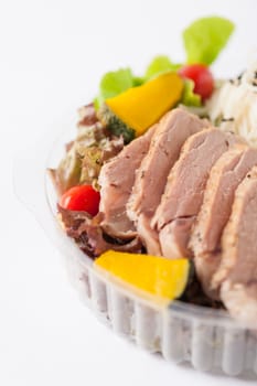 Salad with roasted pork and soba noodles by clean food concept in lunch box on white table