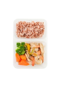 Thai style spicy stir fried shrimps cooked by clean food concept with brown rice and vegetables in lunch box isolated on white background