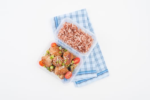 Tsukune (Japanese chicken meatballs) cooked by clean food concept with brown rice in lunch box on white table