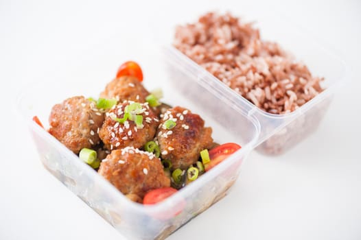 Tsukune (Japanese chicken meatballs) cooked by clean food concept with brown rice in lunch box