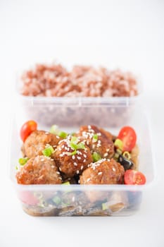Tsukune (Japanese chicken meatballs) cooked by clean food concept with brown rice in lunch box