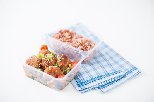 Tsukune (Japanese chicken meatballs) cooked by clean food concept with brown rice in lunch box