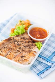 Roasted pork with three flavoured (sweet, sour, spicy) sauce cooked by clean food concept with vegetables in lunch box