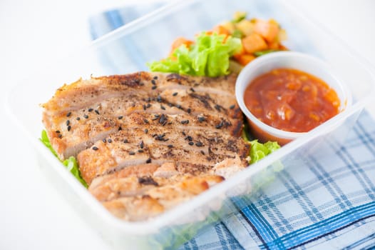Roasted pork with three flavoured (sweet, sour, spicy) sauce cooked by clean food concept with vegetables in lunch box