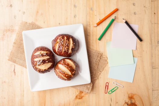 Notebook and sticky paper, paper clip, color pencil, and pen on wood table in vintage style