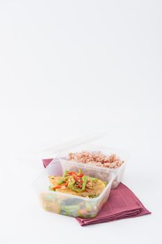 Pangasius fish fried with chili and vegetables cooked by clean food concept with brown rice in lunch box on white table